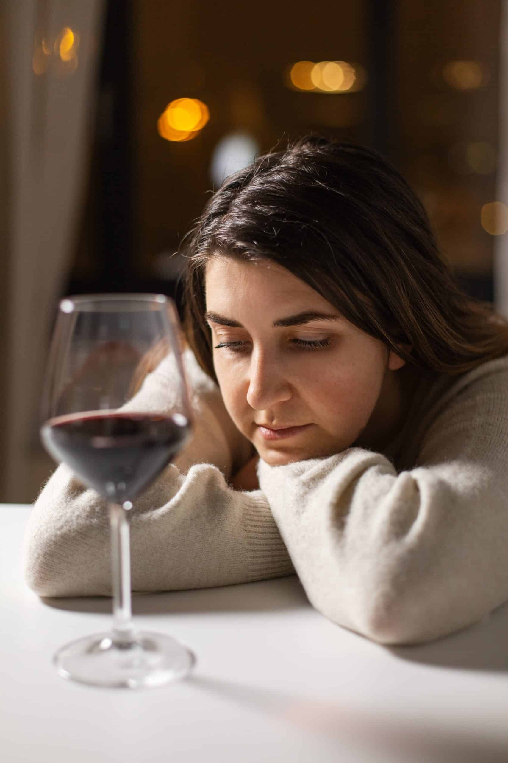 Woman battling alcoholism with a glass of wine.